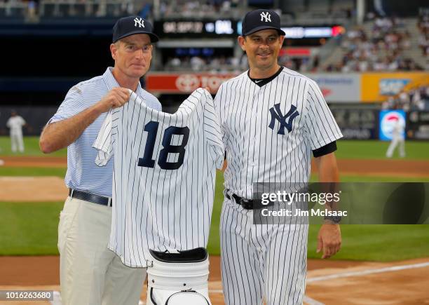 United States Ryder Cup Captain Jim Furyk and New York Yankees manager Aaron Boone exchange gifts prior to a game between the Yankees and the New...