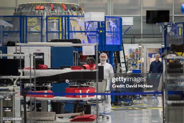 Engineers inside a clean room help construct the Crew Dragon spacecraft during a media tour of SpaceX headquarters and rocket factory on August 13,...