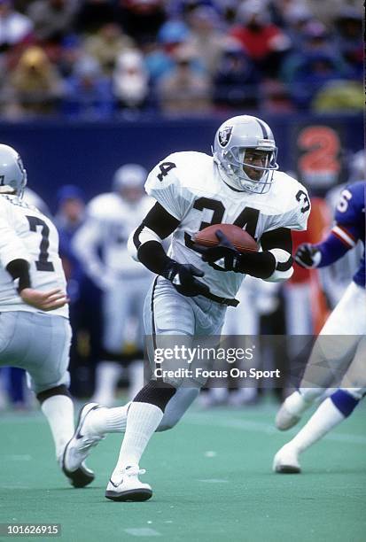 Running back Bo Jackson of the Los Angeles Raiders carries the ball against the New York Giants December 24, 1989 during an NFL game at Giant Stadium...