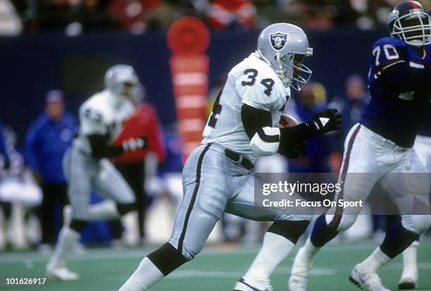 Running back Bo Jackson of the Los Angeles Raiders carries the ball against the New York Giants December 24, 1989 during an NFL game at Giant Stadium...