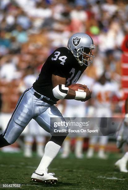 S: Running back Bo Jackson of the Los Angeles Raiders carries the ball against the Kansas City Chiefs circa late 1980's during an NFL Football game...