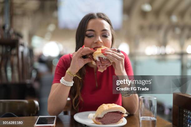 vrouw tradicional mortadela brood eten in gemeentelijke markt in sao paulo, brazilië - municipal market of sao paulo stockfoto's en -beelden