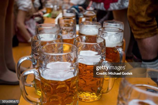 beer steins on table during beer fest in munich germany - bierfest stockfoto's en -beelden