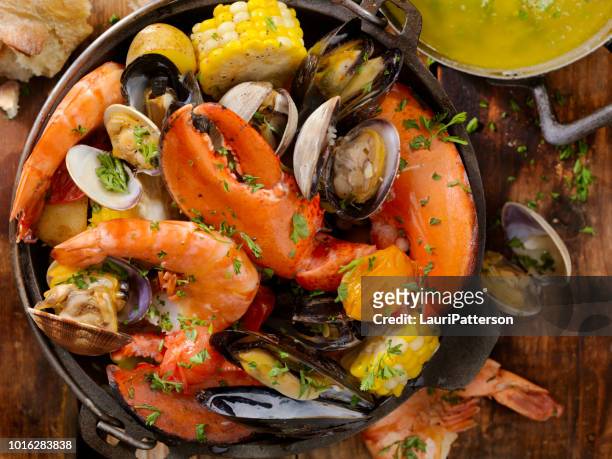 schaal-en schelpdieren bakken met groenten - crab pot stockfoto's en -beelden