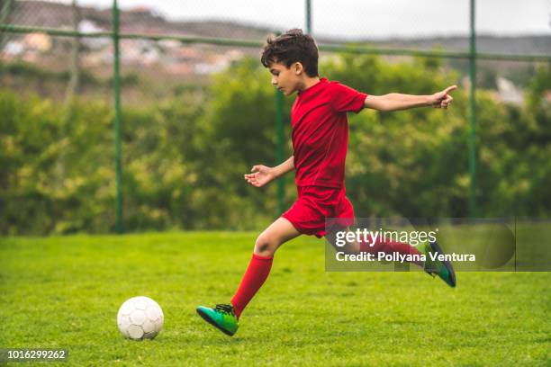 boy preparing to kick the ball - kids football stock pictures, royalty-free photos & images