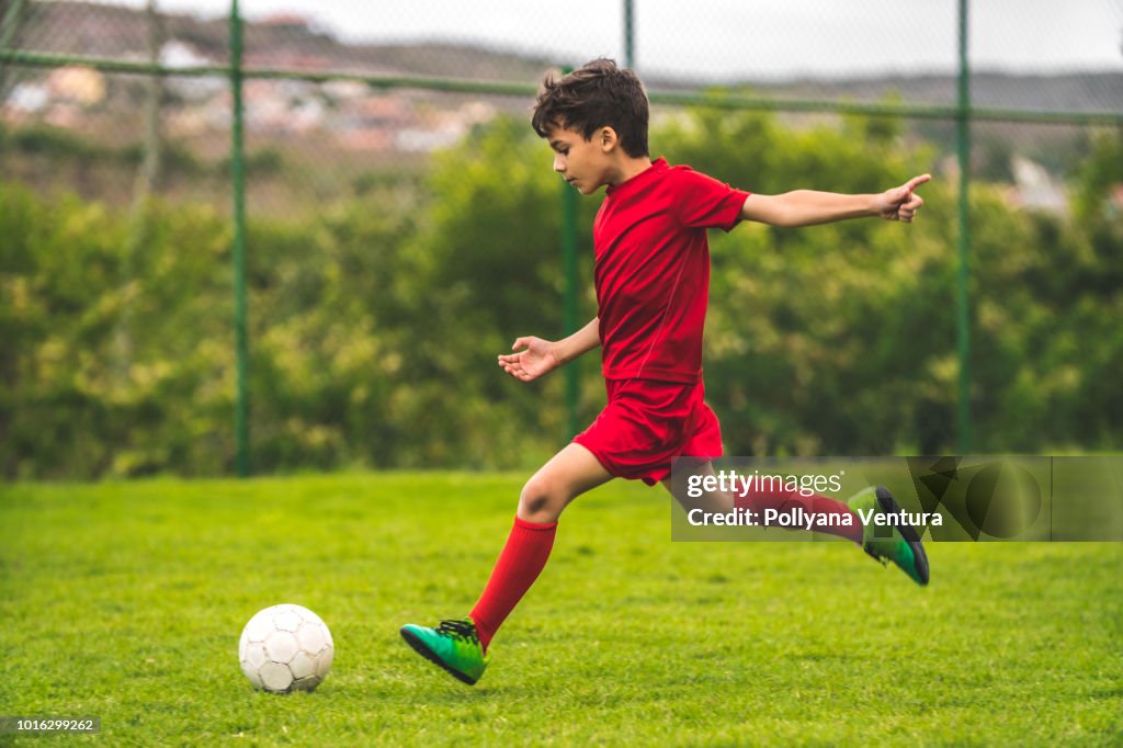 Rapaz, se preparando para chutar a bola