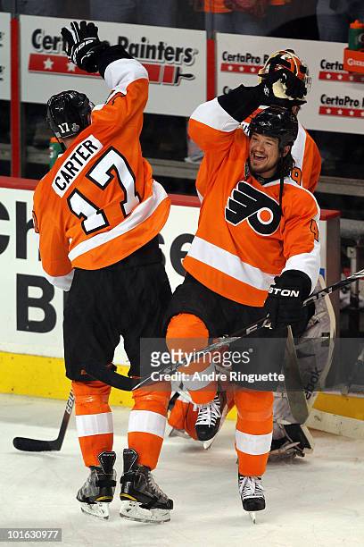 Jeff Carter of the Philadelphia Flyers celebrates with teammate Arron Asham after scoring an empty-net goal in the third period against the Chicago...