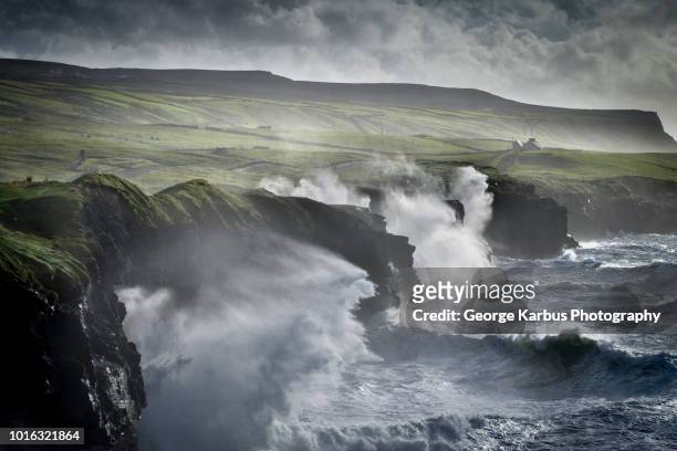 waves crashing against the cliffs of moher, doolin, clare, ireland - geërodeerd stockfoto's en -beelden