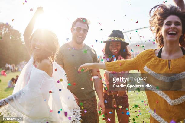young adult friends throwing and dancing in confetti at holi festival - music festival day 4 foto e immagini stock