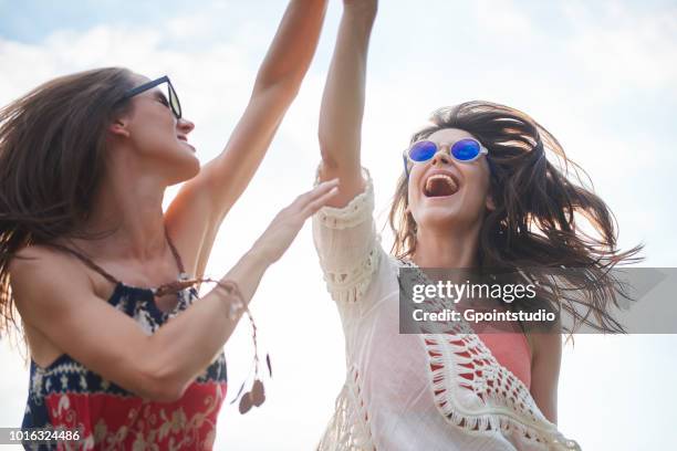 friends dancing with arms raised in music festival - woman at festival ストックフォトと画像