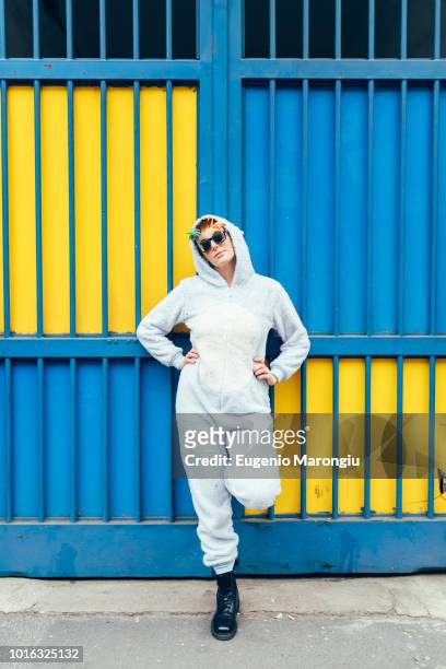 portrait of woman wearing adult bodysuit, hands on hips looking at camera - white jump suit stock pictures, royalty-free photos & images