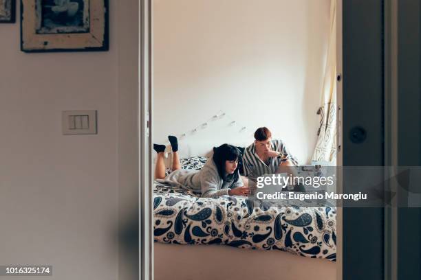 women relaxing on bed using laptop - doorway stock pictures, royalty-free photos & images