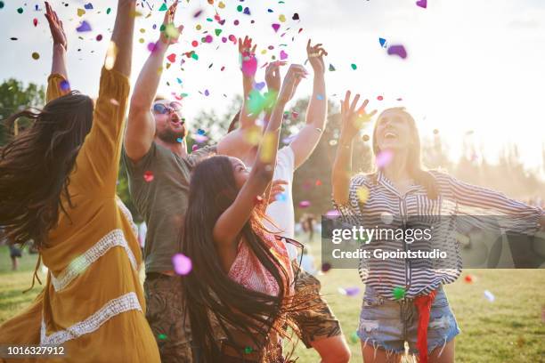 five young adult friends throwing confetti mid air at holi festival - カトヴィッツェ ストックフォトと画像