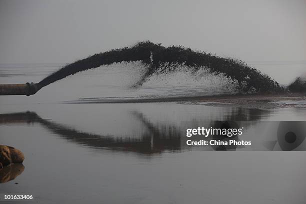 Pipe spouts silt at a land reclamation site of the Tanggu Coastal Economic Zone on June 4, 2010 in Tanggu of Tianjin Municipality, China. From 2002...