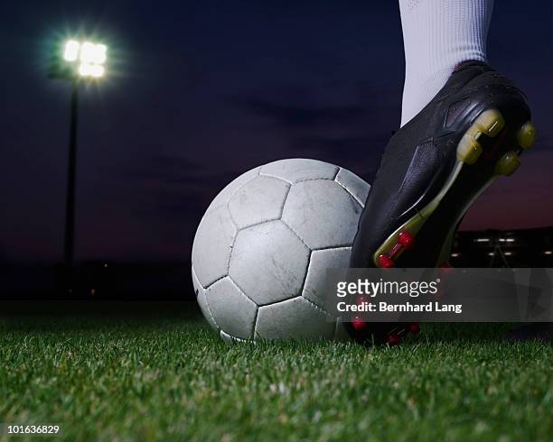 soccer player kicking ball in stadium,  - studded stock-fotos und bilder