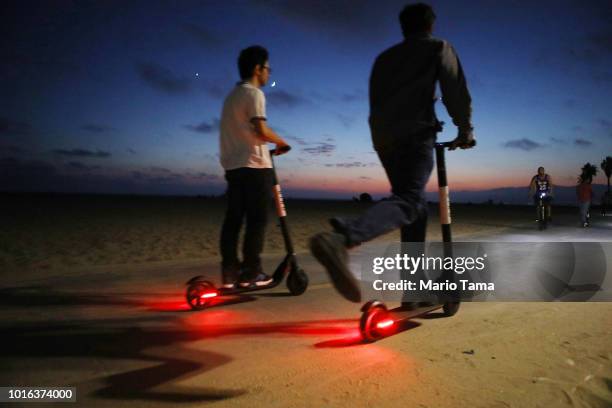 People ride shared dockless electric scooters along Venice Beach on August 13, 2018 in Los Angeles, California. Shared e-scooter startups Bird and...