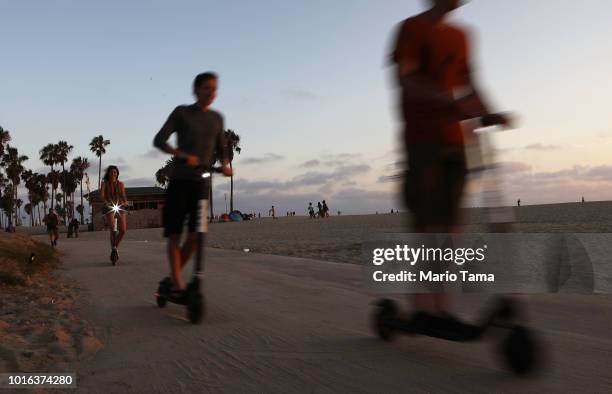 People ride shared dockless electric scooters along Venice Beach on August 13, 2018 in Los Angeles, California. Shared e-scooter startups Bird and...