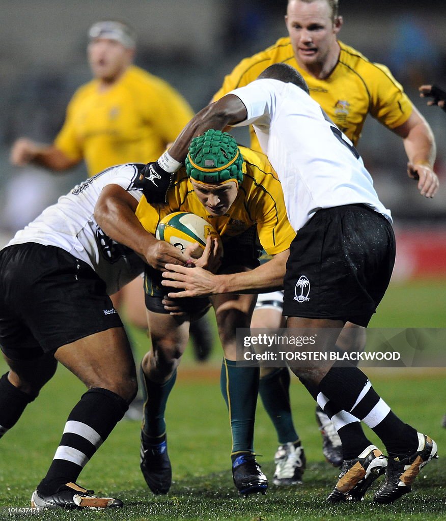 Wallaby centre Matt Giteau (C) tries to