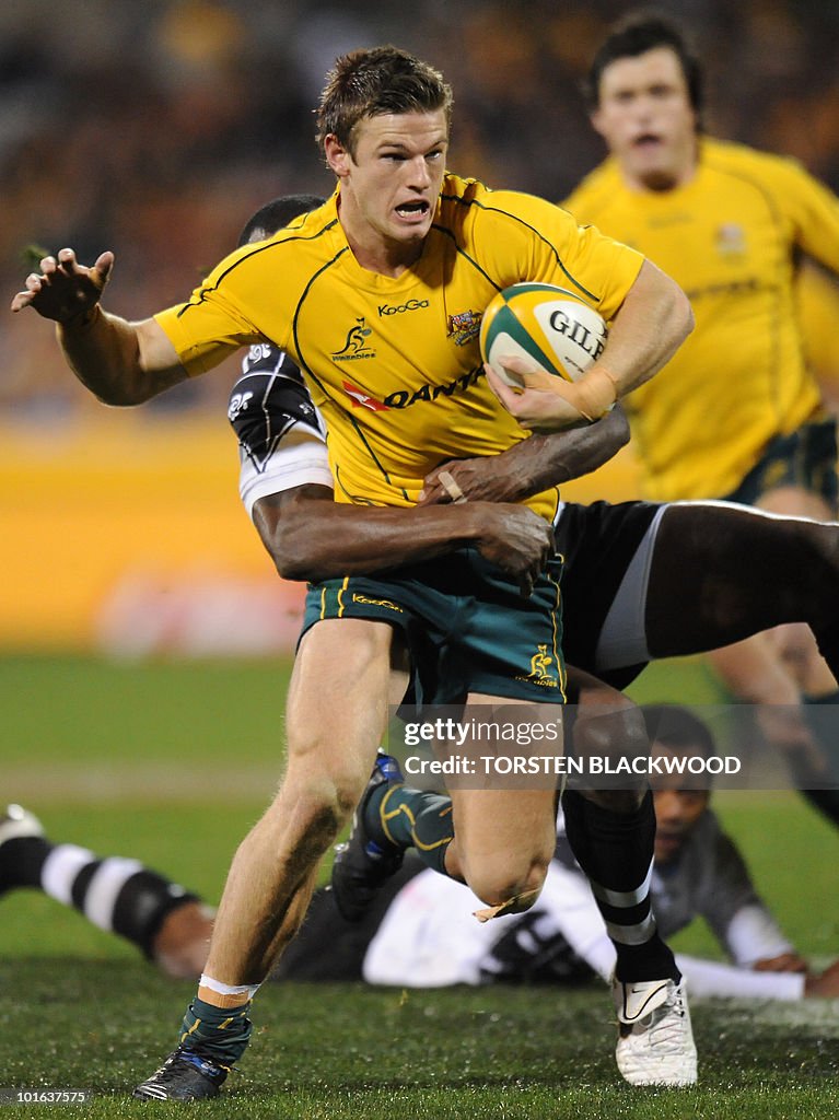 Wallaby centre Rob Horne is tackled as h