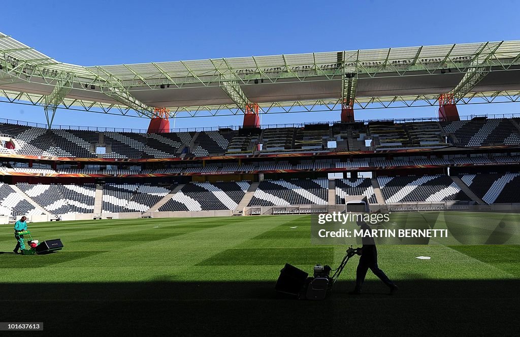 A worker cuts the grass of the field of