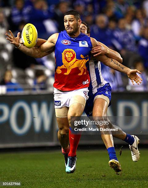 Brendan Fevola of the Lions attempts to gather the ball under pressure from Scott Thompson of the Kangaroos during the round 11 AFL match between the...