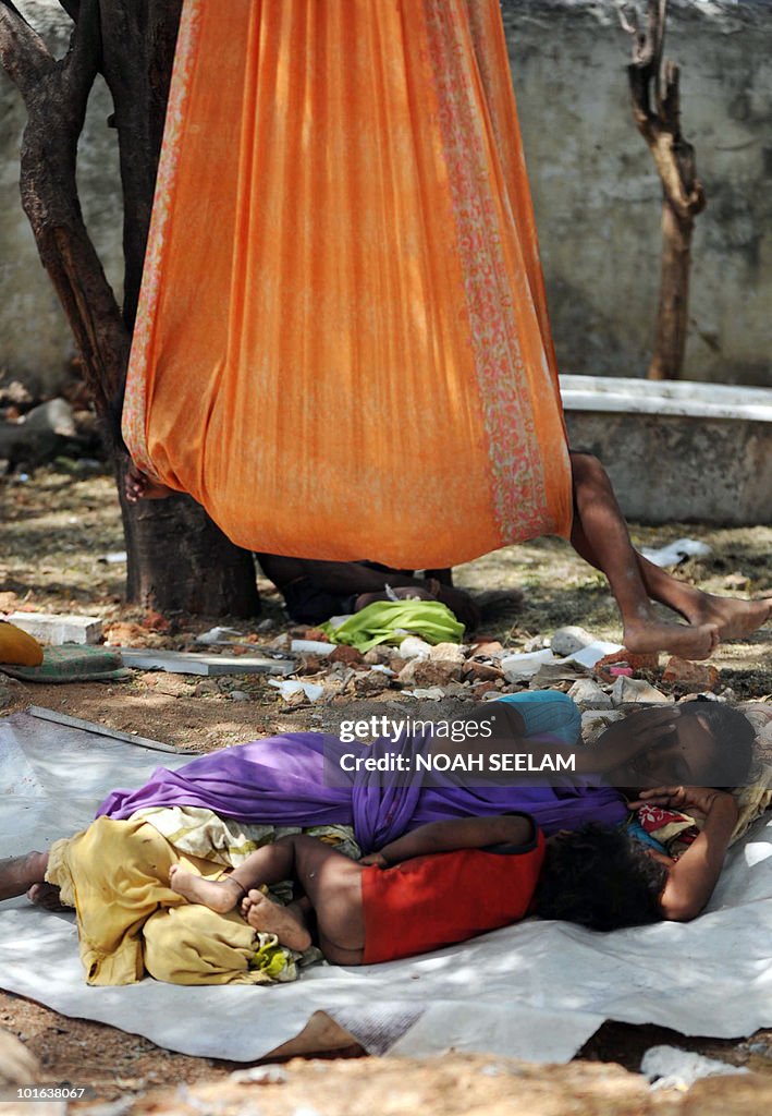 An Indian woman labourer and child sleep