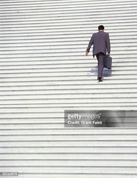 businessman walking up stairs - walking up stairs stockfoto's en -beelden
