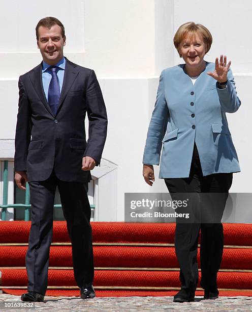 Angela Merkel, Germany's chancellor, right, walks with Dmitry Medvedev, Russia's president, ahead of their joint press conference at Meseberg Castle...