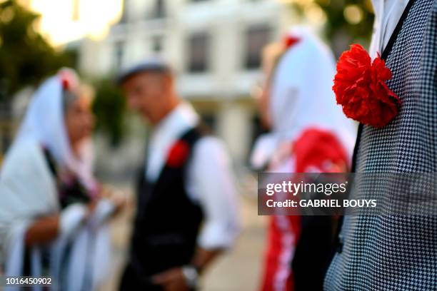 People dressed in Madrid's traditional attire "Chulapos" attend the Feast of La Paloma Virgin in Madrid on August 13, 2018. - Madrid's history and...