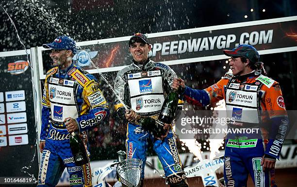 Poland's Jaroslaw Hampel celebrates with champaign after winning the Danish Speedway Grand Prix on the podium with second placed Tomasz Gollob of...
