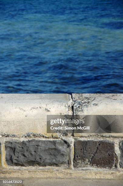 concrete footpath and low stone wall on the esplanade overlooking port phillip bay, victoria, australia - niedrig stock-fotos und bilder