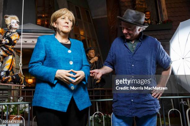 Sculptor Gottfried Krueger poses with the wax figure of German Chancellor Angela Merkel, which he created, during its presentation day at Panoptikum...
