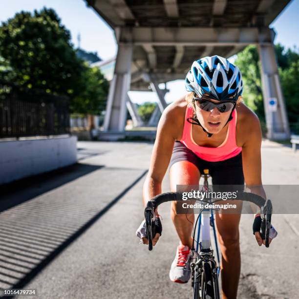 sportliche frau radsport rennrad in der stadt - female on bike stock-fotos und bilder