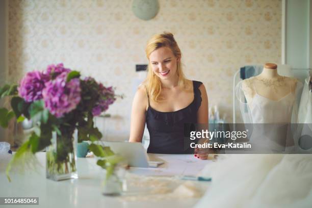 fashion designer is taking notes on a laptop - event planner stock pictures, royalty-free photos & images
