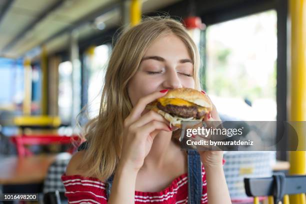 食事には、ハンバーガー女性 - 盛り付け 手 ストックフォトと画像