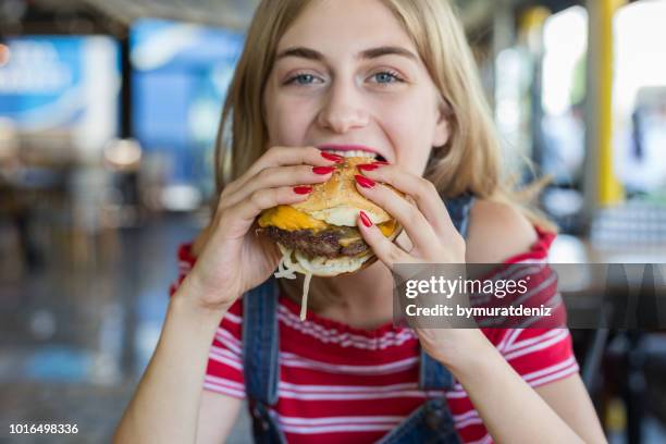 frau burger essen - dirty face stock-fotos und bilder