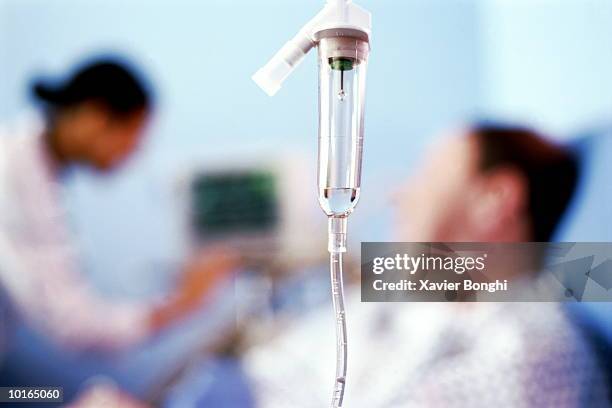 Man In Hospital Bed Nurse Checks Monitor High-Res Stock Photo