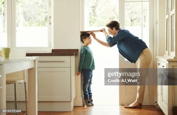 wow, you've really grown quite a bit! - measuring child stock pictures, royalty-free photos & images