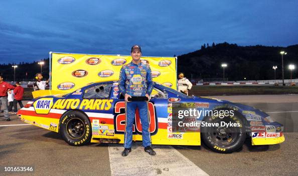 Eric Holmes Racing Eric Holmes holds his trophy as he poses in front of his car after ...
