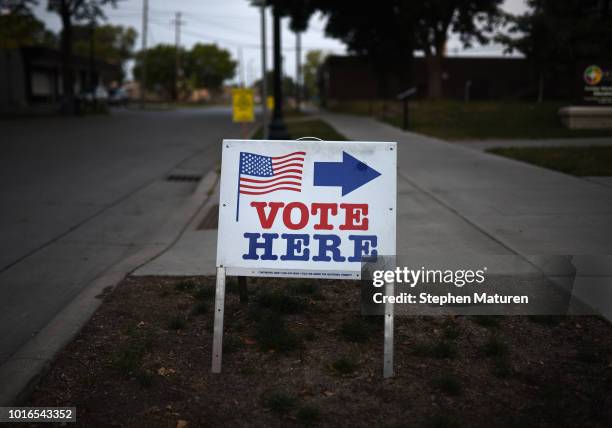 Sign reading "Vote Here" points toward a polling place for the 2018 Minnesota primary election at Holy Trinity Lutheran Church on August 14, 2018 in...