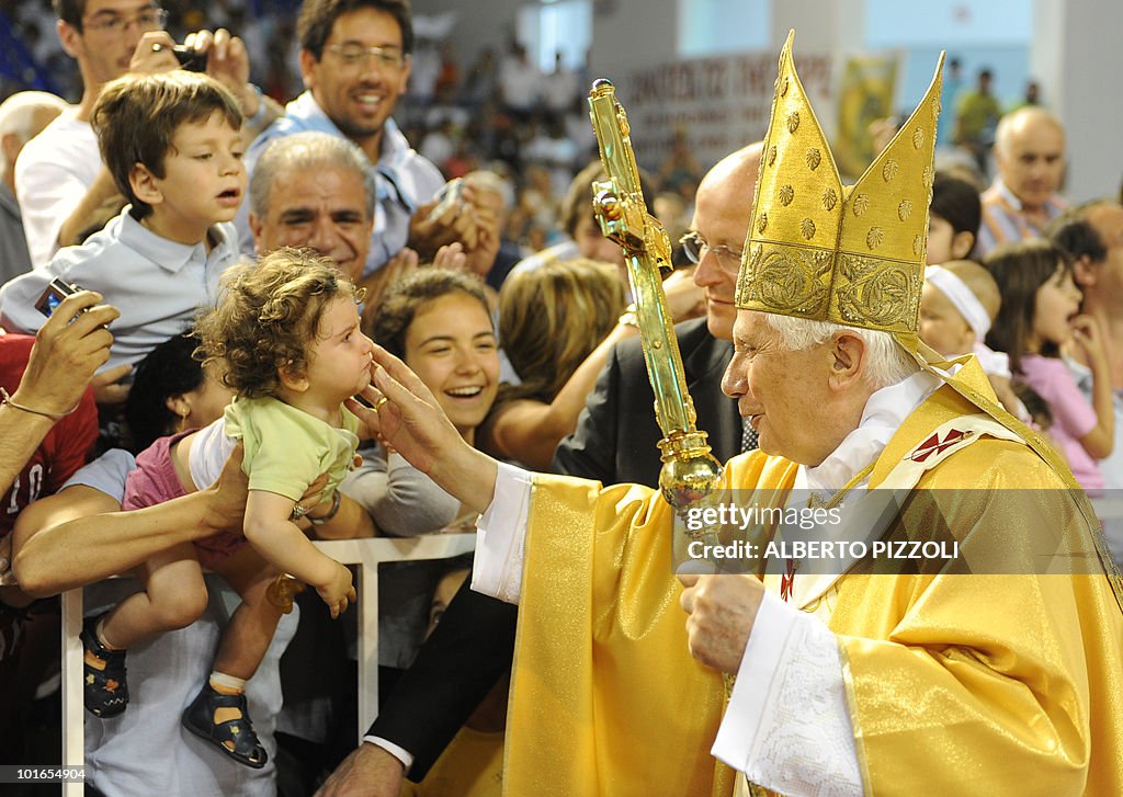 Pope Benedict XVI greets a toddler as he