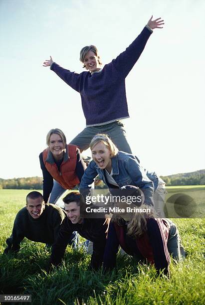 college friends building pyramid - human pyramid stock pictures, royalty-free photos & images