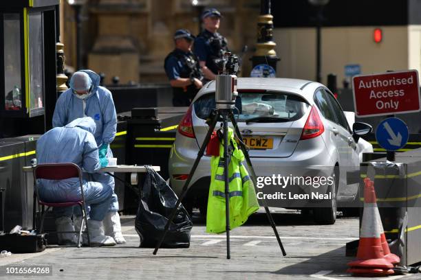 Forensic officers continue their work around a vehicle after it crashed into security barriers, injuring a number of pedestrians, early this morning,...