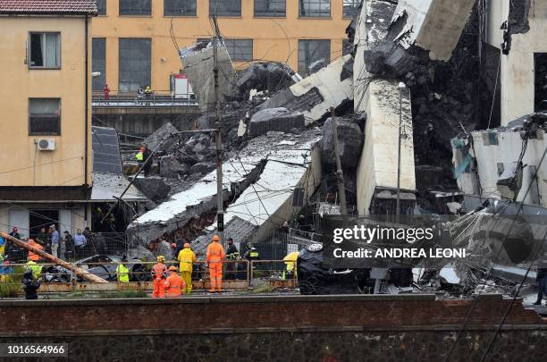 Rescuers scour through the rubble and wreckage after a Morandi motorway bridge collapsed earlier in Genoa on August 14, 2018. - At least 22 people...