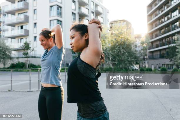 young woman stretching with fitness group - german indian society stock pictures, royalty-free photos & images