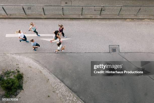 women's fitness group running through city - germany womens training stockfoto's en -beelden