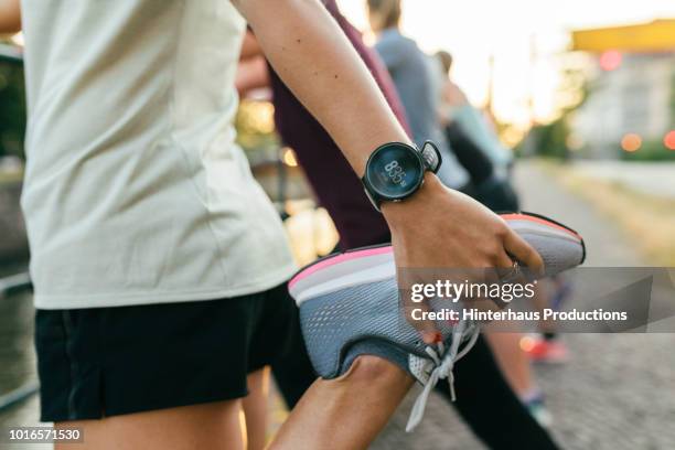 close up of woman stretching before run - grey shoe photos et images de collection