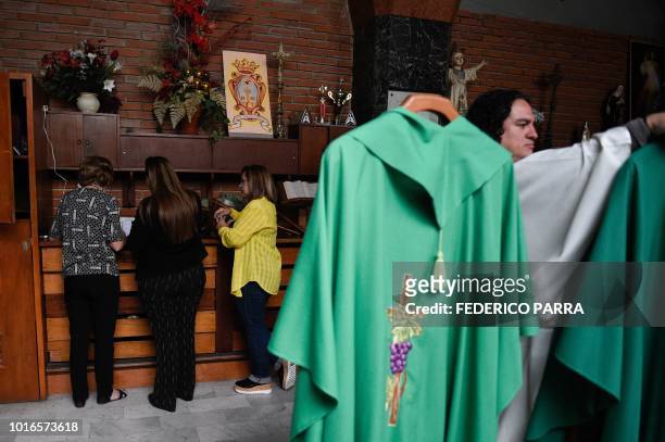 Catholic faithful pay the tithe with debit card, after mass at La Coromoto Church, in Caracas on August 12, 2018. - The shortage of cash in the...