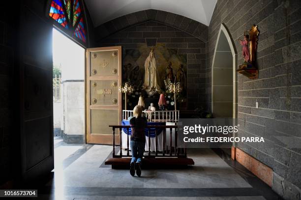 Catholic faithful attends mass at La Coromoto Church, in Caracas on August 12, 2018. - The shortage of cash in the country has forced churches to...