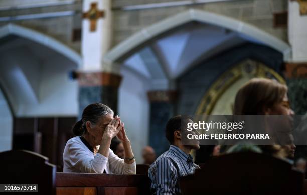 Catholic faithful attend mass at La Coromoto Church, in Caracas on August 12, 2018. - The shortage of cash in the country has forced churches to...